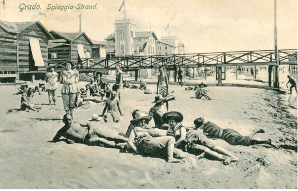 Bagnanti sulla spiaggia di Grado in una cartolina d'epoca