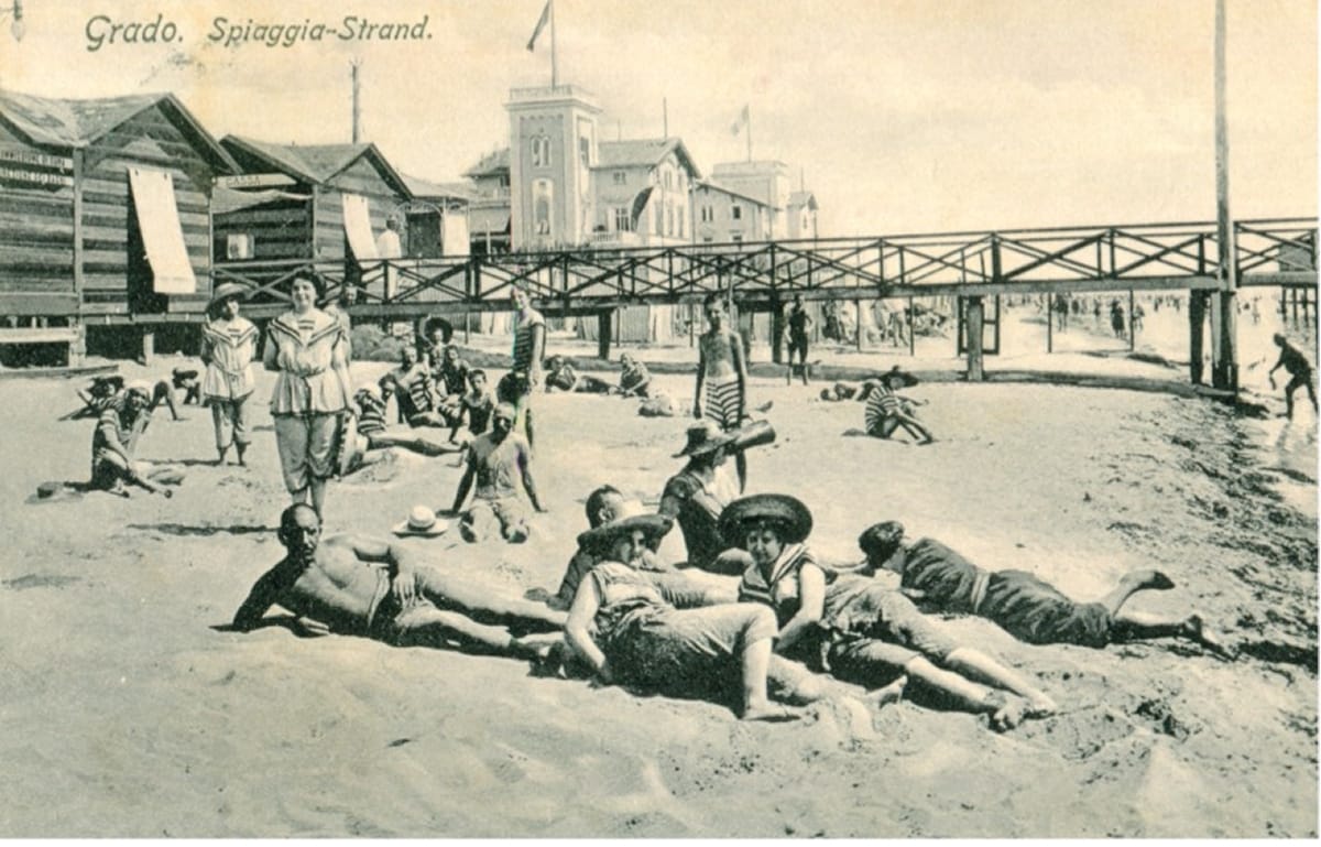Bagnanti sulla spiaggia di Grado in una cartolina d'epoca