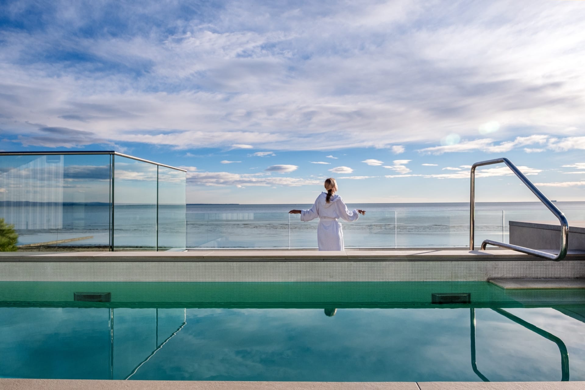 Ospite in accappatoio davanti alla piscina panoramica