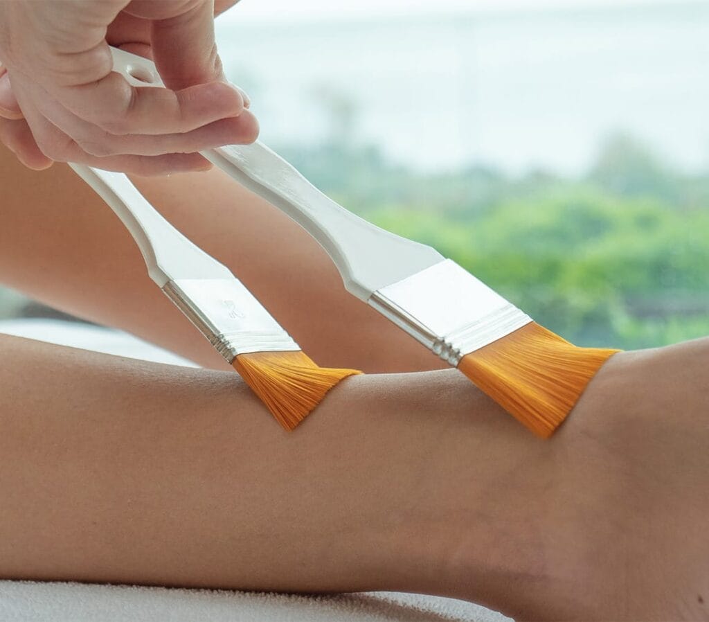 Applicazione di un trattamento corpo con il pennello